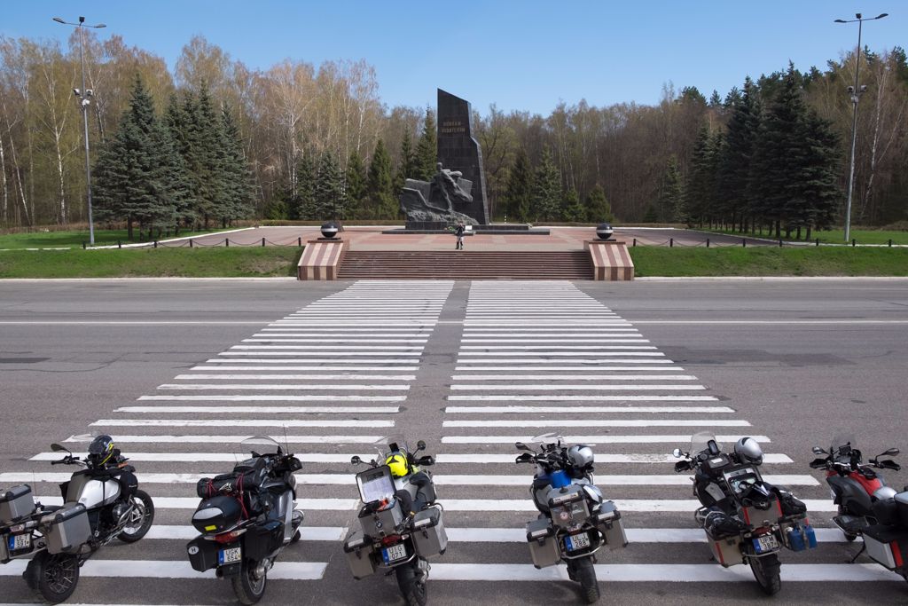 A motorok farkasszemet néznek a brjanszki háborús emlékművel és Gáborral, a túravezetővel aki minket fényképez az út túloldaláról.