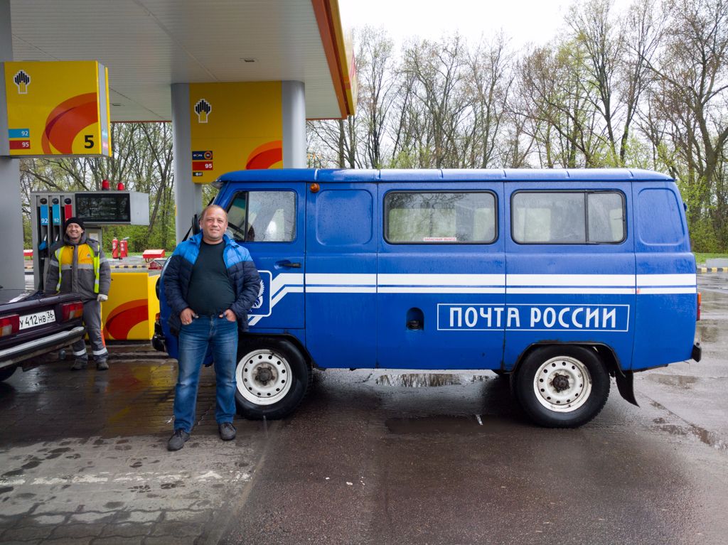 Az orosz postás boldogan pózolt az autójával egy fényképhez.